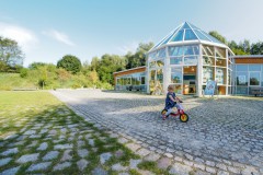 Kind fährt mit Laufrad vor dem NaturParkZentrum am Wildgehege Glauer Tal